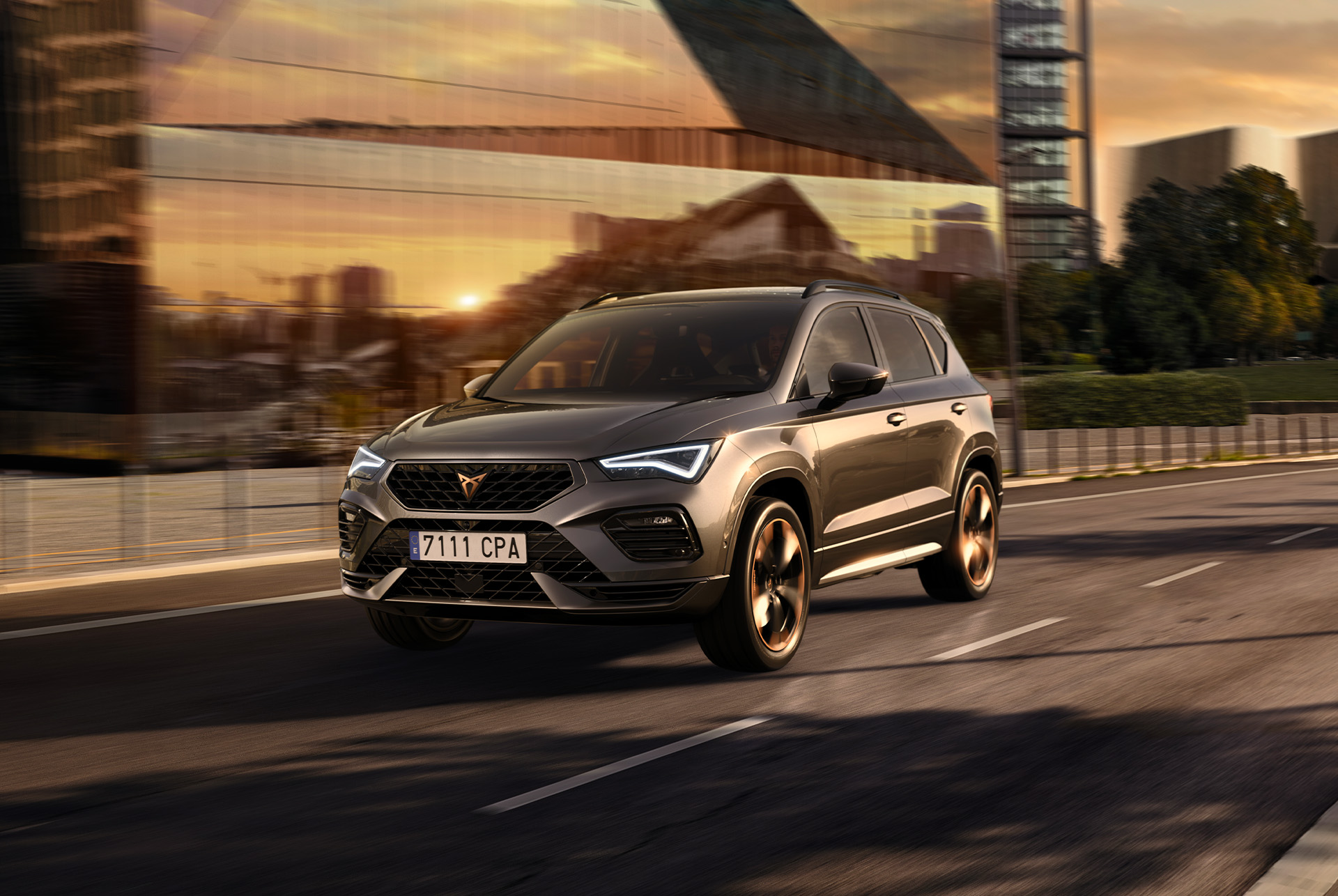 Kuvassa harmaa CUPRA Ateca SUV valkoista taustaa vasten. Autossa on rohkea etusäleikkö, led-ajovalot ja kuparisomisteiset kevytmetallivanteet, jotka yhdessä korostavat auton urheilullista ilmettä.